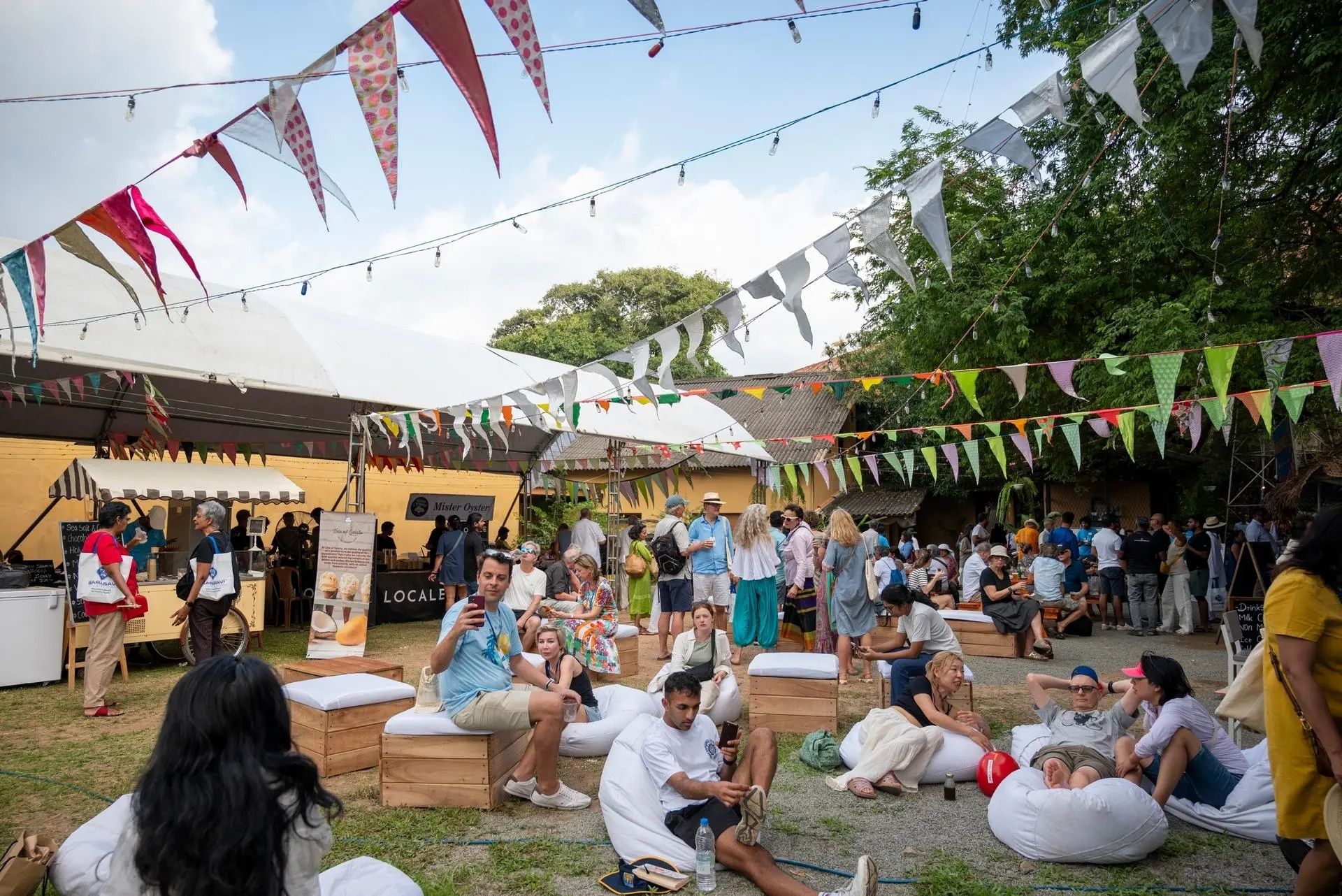 Festival-goers relaxing on beanbags beneath colourful bunting